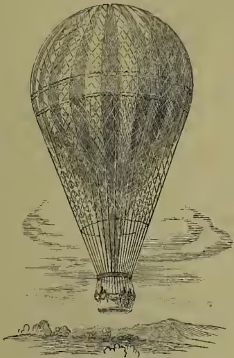 A detailed black and white illustration of a hot air balloon. The balloon is spherical with a fine mesh or net-like texture. It is suspended by a basket or gondola at the bottom, which is also made of a similar material. The basket is attached to the balloon by several ropes. The balloon is shown floating above a small, stylized landscape with hills and a body of water. The sky is depicted with some light, wispy clouds.