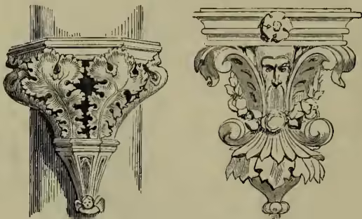 Two ornamental brackets, one showing a side profile and the other a front view, both featuring intricate carvings and scrolls.