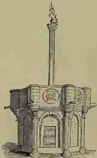 A detailed black and white illustration of the Edinburgh Old Market-cross. It is a tall, square stone structure with a central arched doorway at the base. The structure is topped by a tall, slender stone shaft that ends in a small, ornate cross. The base is decorated with carvings and has a small arched entrance.
