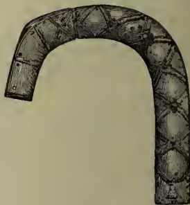 A black and white illustration of a Celtic brooch, specifically the Quigrich of St Fillan. It is a large, U-shaped brooch with a decorative, interlaced pattern on its surface. The brooch is shown from a side-on perspective, highlighting its curved form and the intricate knotwork design.
