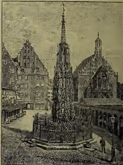 A detailed black and white engraving of the Schönbrunnen Fountain in Nuremberg. The fountain is a tall, octagonal structure with a highly ornate, Gothic-style spire topped by a weather vane. It is surrounded by a low, decorative fence. In the background, there are several buildings, including a large church with a prominent tower. The scene is set in a town square with a cobblestone ground and a few figures visible in the distance.