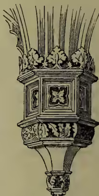 An ornate, decorative pendant ornament, likely a chandelier or ceiling decoration, featuring intricate carvings and a central floral motif.